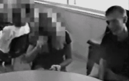 a man and two women are sitting at a table in a black and white photo .