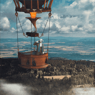 a man in a hot air balloon is looking out over a valley