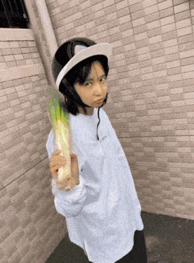 a person wearing a helmet and holding a bunch of greens