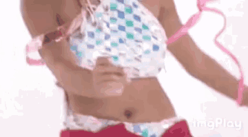 a woman in a bikini is holding a pink ribbon around her neck .