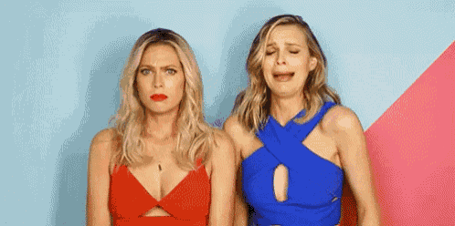 two women are standing next to each other and making funny faces .