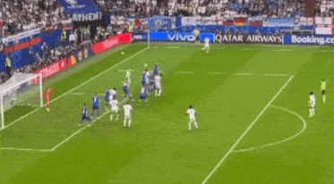a soccer field with a qatar airways ad on the side of it