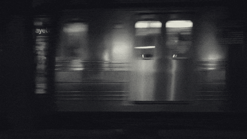 a black and white photo of a train that is going down the tracks