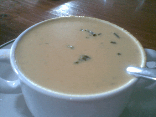 a cup of creamy soup with a spoon in it