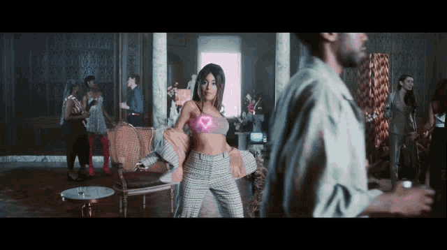 a woman with a pink heart on her chest is dancing