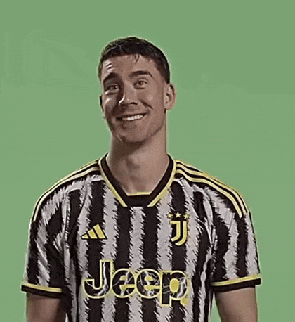 a man in a black and white striped jeep jersey is smiling and making a funny face .