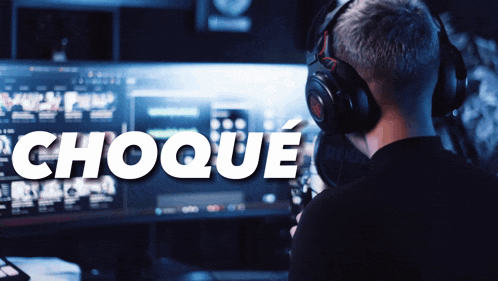 a man wearing headphones stands in front of a computer screen with the word choque written on it