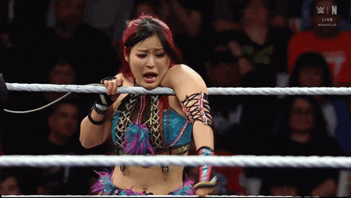 a woman in a wrestling ring with the letters w on the bottom right
