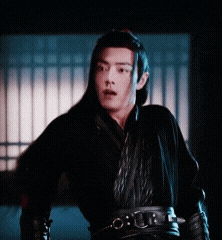 a man with long hair is wearing a black kimono