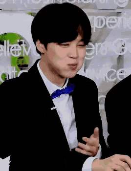 a man in a suit with a blue bow tie