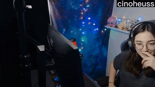 a woman wearing headphones sits in front of a hp computer