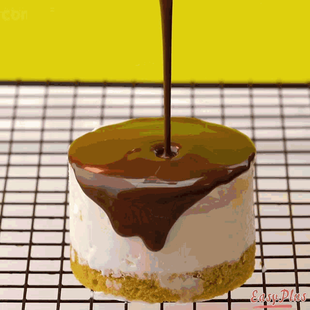 a piece of cake with chocolate being poured on it and the words easy plus written on the bottom