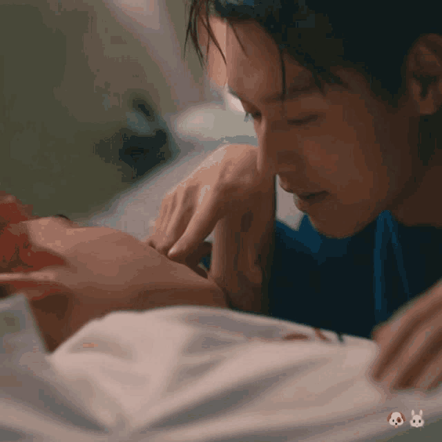 a man in a blue shirt is touching another man 's neck