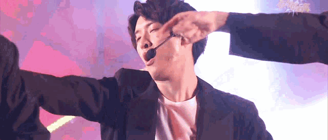 a man with a microphone on his head is being touched by another man