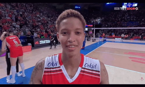 a volleyball player wearing a red and white jersey with the word orkid on the front