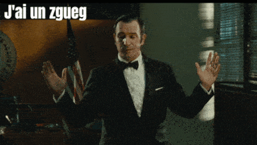 a man in a tuxedo stands in front of an american flag with the words gros comme ca written above him