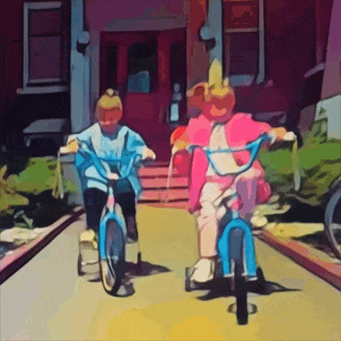 two little girls are riding bicycles down a sidewalk in front of a house
