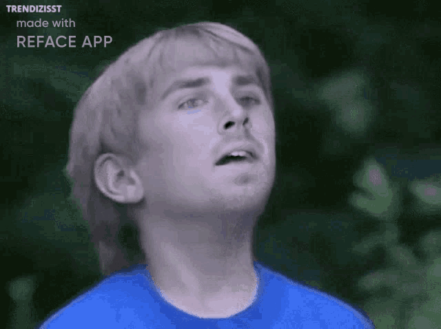 a man in a blue shirt is looking up in the air .