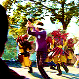 a group of people in costumes are dancing on a street