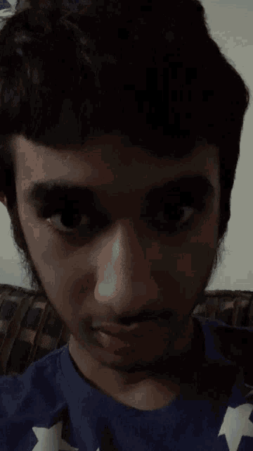 a young man with a beard is wearing a blue shirt with white stars