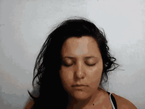 a woman with her eyes closed is wearing a black top