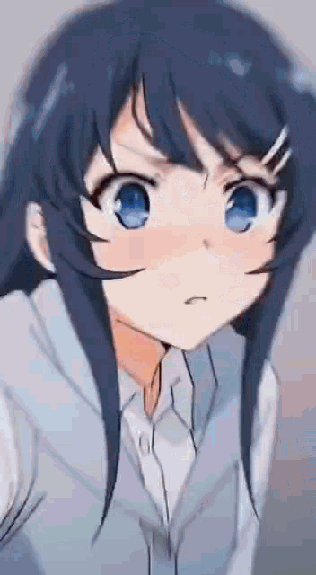 a girl with long black hair and blue eyes is looking at the camera with an angry look on her face .