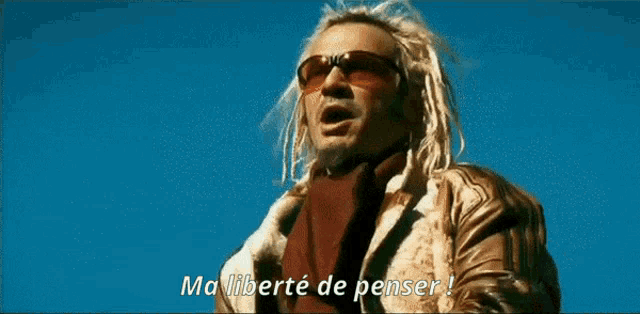 a man with long blonde hair is wearing sunglasses and says ma liberte de penser !