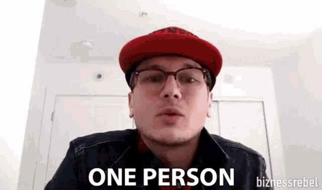 a man wearing a red hat and glasses says one person .