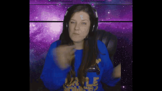 a woman wearing headphones and a blue shirt that says ' ucla ' on it