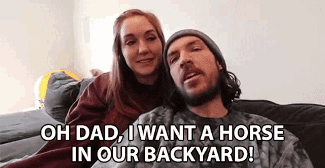 a man and a woman are sitting on a couch and the man is asking the woman if she wants a horse in her backyard