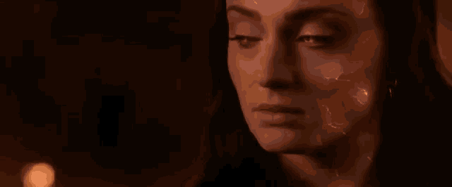 a close up of a woman 's face with red lightning bolts coming out of it .