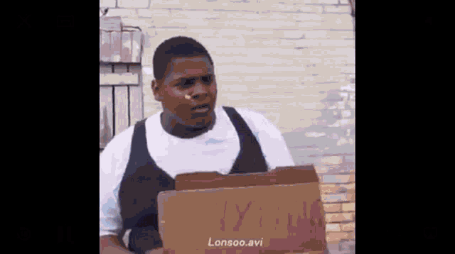 a man is holding a cardboard box that says lonsoo.avi on it .