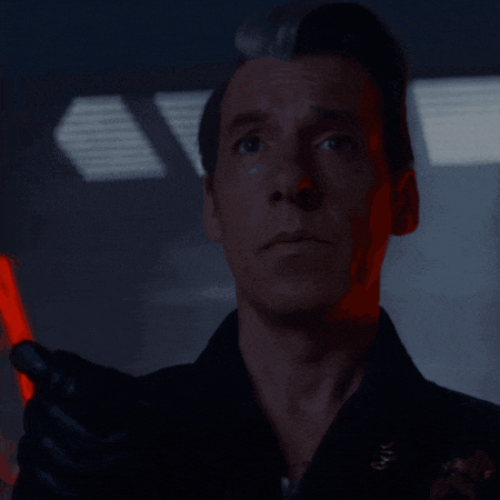 a man in a black jacket holds a red light