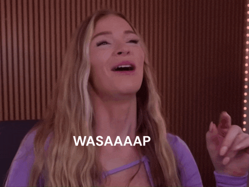 a woman in a purple shirt is laughing with the words wasaaap on the bottom
