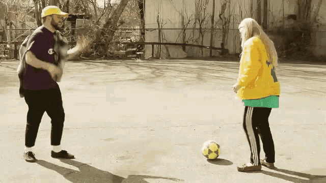 a man and a woman are playing with a ball