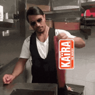 a man in a kitchen with a sign that says " kaira " on it