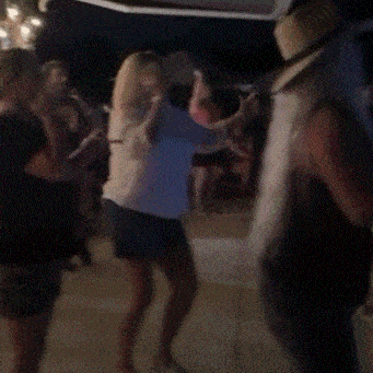 a woman wearing a hat is dancing in a crowd of people