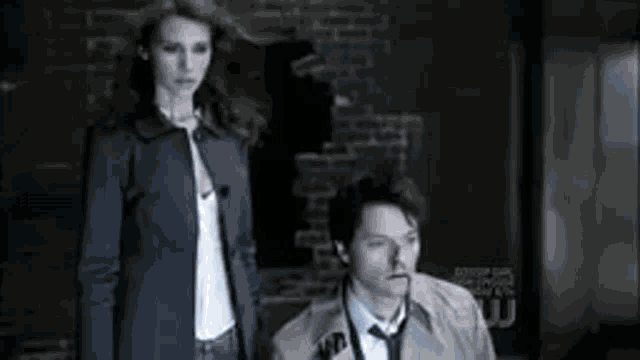 a man and woman are standing next to each other in a dark room .