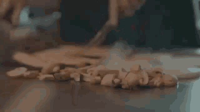 a close up of a person cutting mushrooms on a cutting board .
