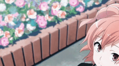a girl with pink hair and red eyes is standing in front of a brick wall with flowers in the background .