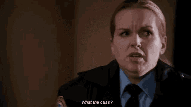 a woman in a police uniform is making a funny face while talking to someone .
