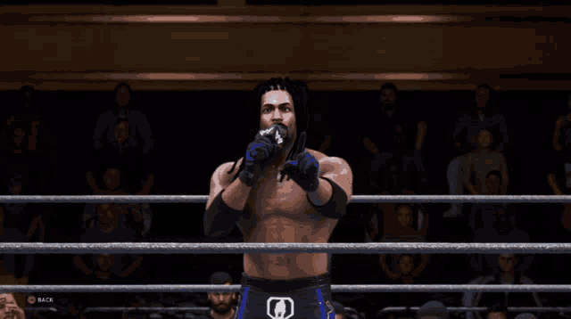 a man in a wrestling ring is wearing gloves that say wwe on them