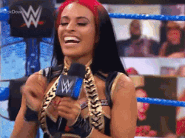 a woman is holding a microphone in a wrestling ring .