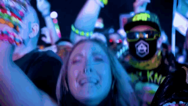 a group of people are dancing at a party and one of them is wearing a mask that says kn on it