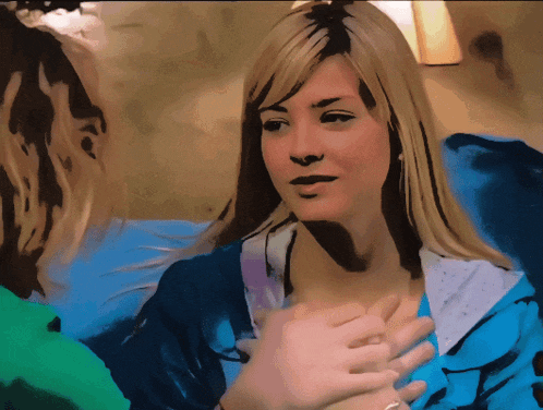 a blonde woman in a blue shirt is talking to another woman