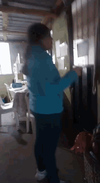 a woman in a blue jacket standing in a room