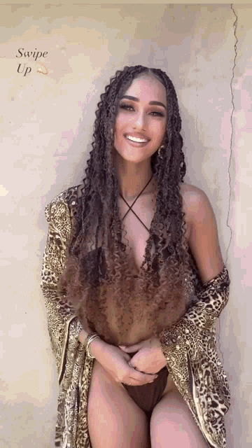 a woman in a bikini and a leopard print robe is smiling with the words swipe up below her
