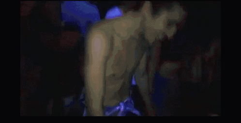 a man in a white shirt with the word mafia on it is dancing in a club .