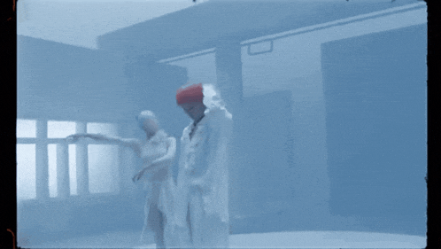 a man and a woman are dancing in a room with a blue background