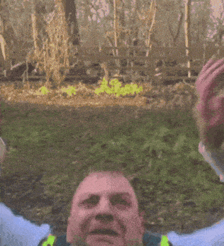 a police officer wearing a yellow vest and tie is screaming with his mouth open .